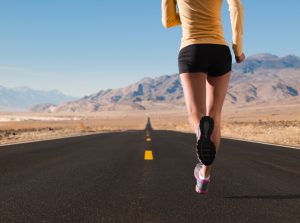 A long distance runner on a remote desert highway.